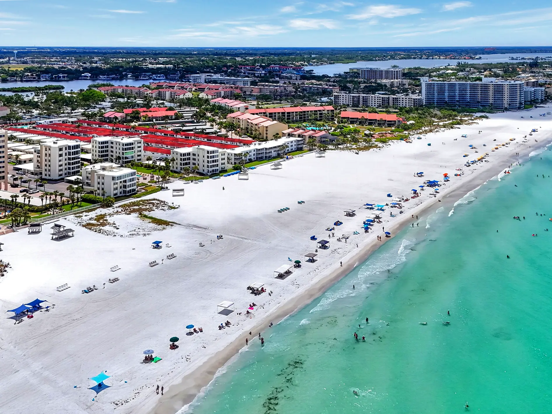Aerial Drone Photography of a luxury land & development property in Siesta Key, Florida. This wide aerial drone view showcasing the beautiful coastal shoreline, turquoise waters, and surrounding premium neighborhood layout on the Florida Gulf Coast, captured with professional real estate media standards.